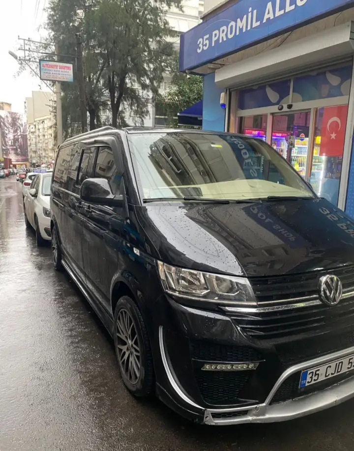 Bina önünde siyah Volkswagen özel transfer aracı