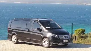 Schwarzes Mercedes-Transferfahrzeug am Meer, Seitenansicht