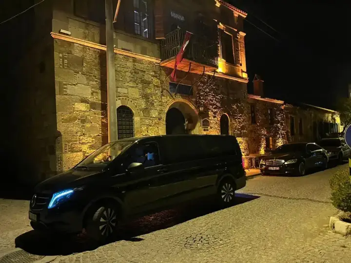 Gece aydınlatılan sokakta siyah Mercedes Vito transfer aracı
