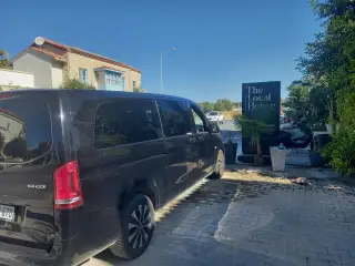 Bina önünde park edilmiş siyah Mercedes Vito transfer aracı