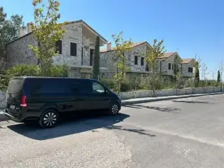 Taş binaların yanında park edilmiş siyah Mercedes Vito