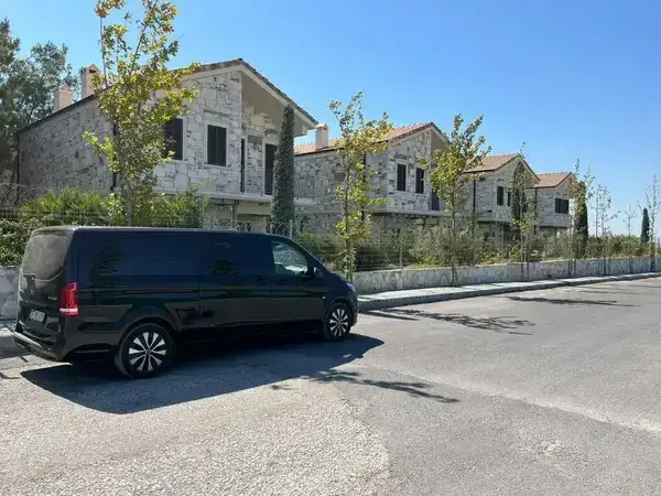 Taş binaların yanında park edilmiş siyah Mercedes Vito