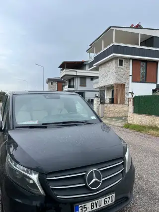 Bina önünde park edilmiş siyah Mercedes Vito transfer aracı