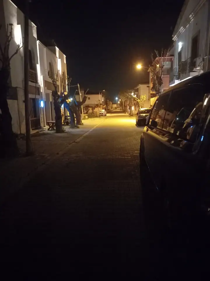 Gece aydınlatılan sokakta siyah Mercedes Vito transfer aracı