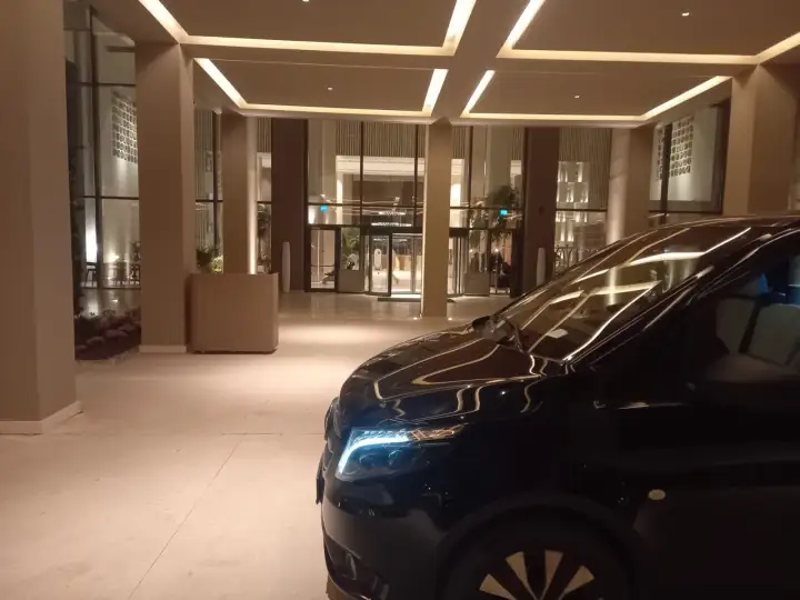 Aydınlatılmış bina girişinde siyah Mercedes Vito