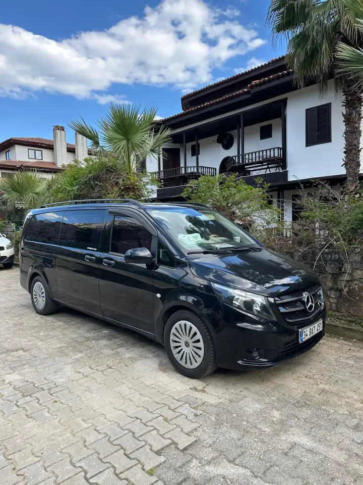 Bina önünde park edilmiş siyah Mercedes Vito transfer aracı