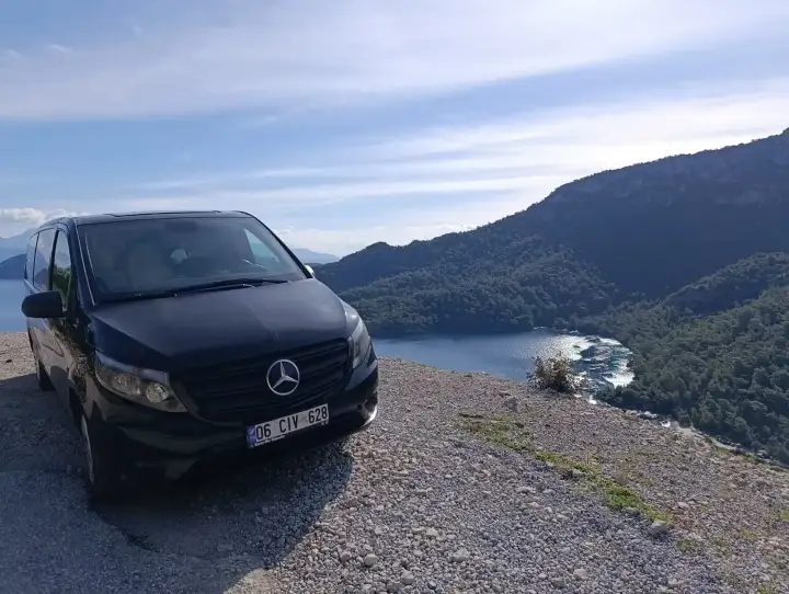Deniz ve kıyı manzarasının yanında park edilmiş siyah Mercedes Vito